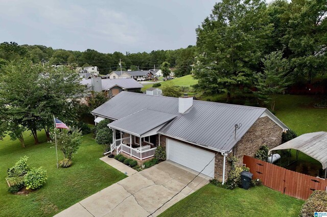 ranch-style house featuring a garage, covered porch, and a front lawn