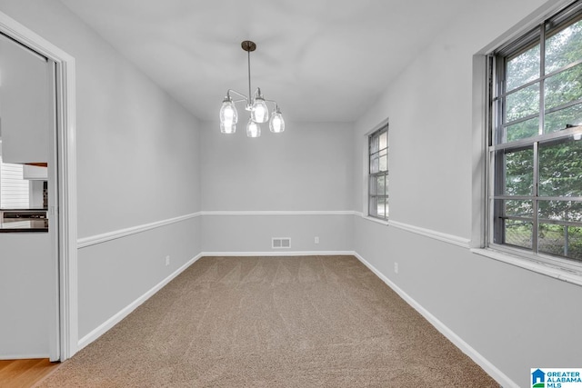 interior space featuring a chandelier, carpet floors, and a wealth of natural light