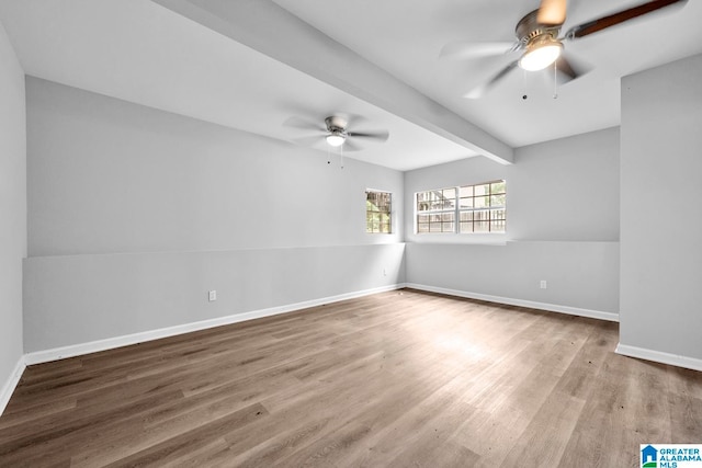 unfurnished room with beamed ceiling, wood-type flooring, and ceiling fan