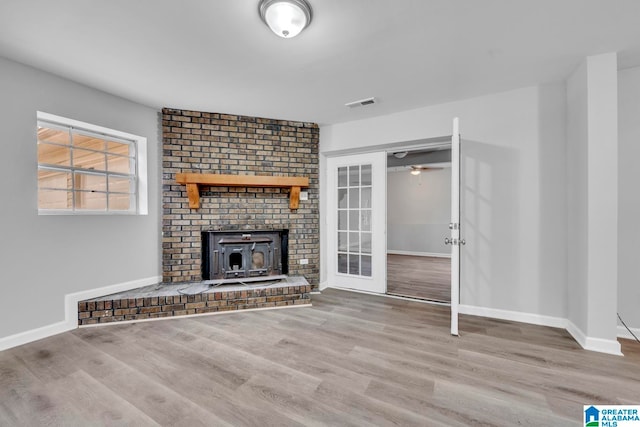 unfurnished living room with a brick fireplace, ceiling fan, and hardwood / wood-style floors