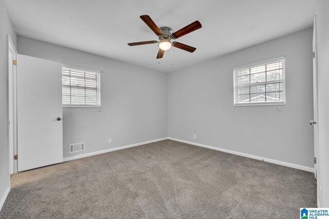 empty room featuring ceiling fan and light colored carpet