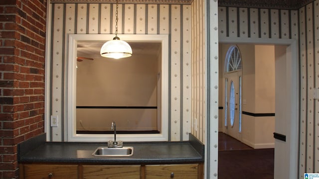 bathroom featuring wallpapered walls and a sink