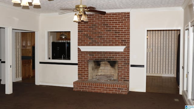 unfurnished living room with a ceiling fan, carpet, a fireplace, ornamental molding, and a textured ceiling