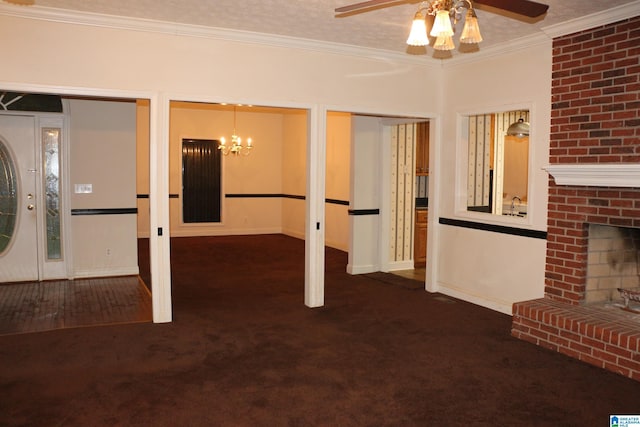 interior space with ornamental molding, ceiling fan with notable chandelier, a textured ceiling, carpet floors, and a brick fireplace