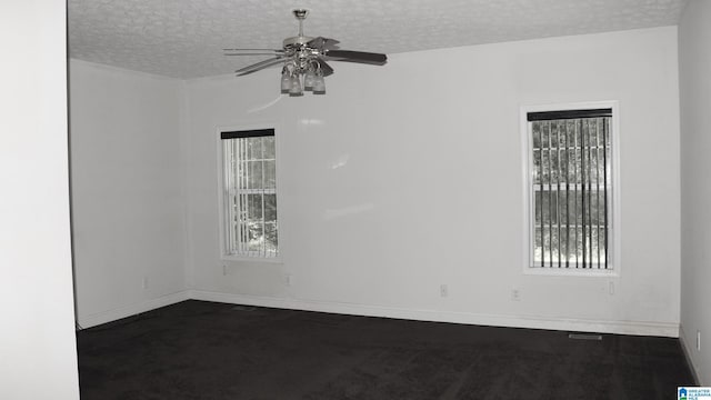 empty room featuring a textured ceiling, baseboards, and a ceiling fan