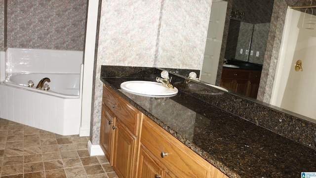 bathroom featuring vanity and tiled tub