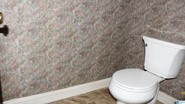 bathroom with baseboards and toilet