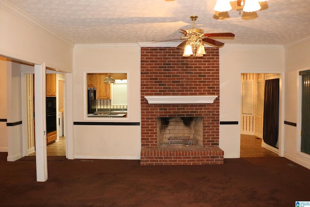 unfurnished living room featuring carpet, ceiling fan, ornamental molding, a textured ceiling, and a brick fireplace