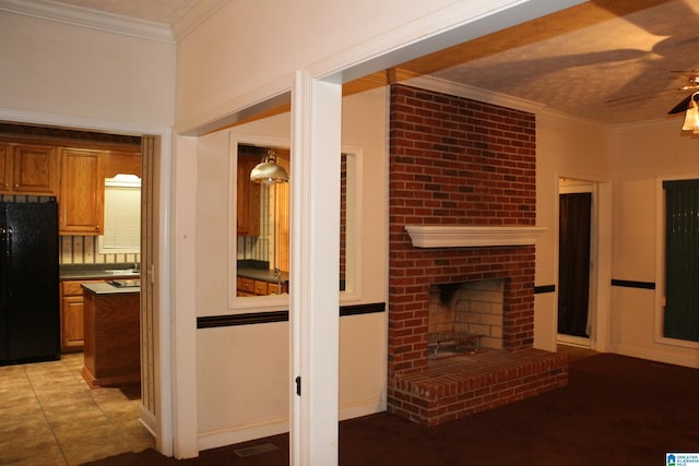 living room featuring visible vents, crown molding, light tile patterned floors, a brick fireplace, and ceiling fan