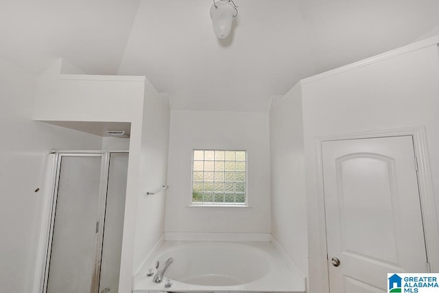 bathroom featuring plus walk in shower and vaulted ceiling