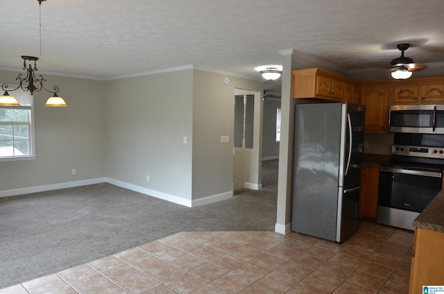 kitchen with appliances with stainless steel finishes, pendant lighting, ornamental molding, ceiling fan, and light carpet