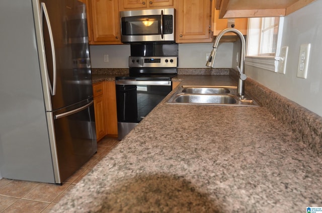 kitchen with sink, light tile patterned floors, and appliances with stainless steel finishes