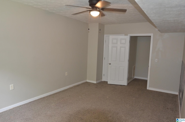 unfurnished bedroom featuring ceiling fan, a textured ceiling, and carpet flooring