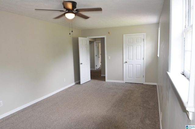 unfurnished bedroom with ceiling fan and carpet