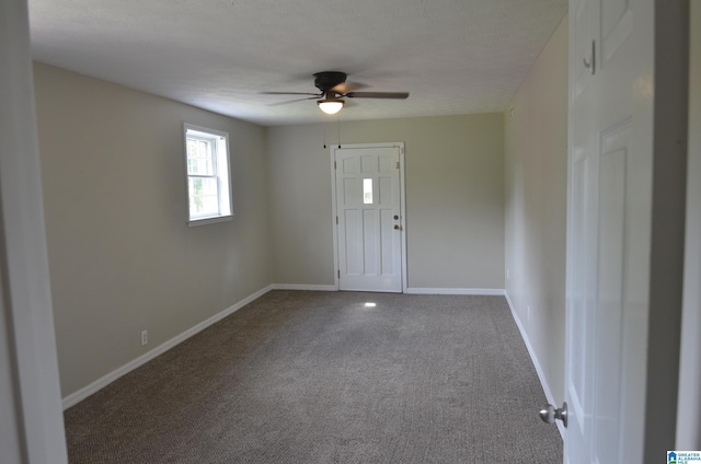 entrance foyer featuring ceiling fan and carpet