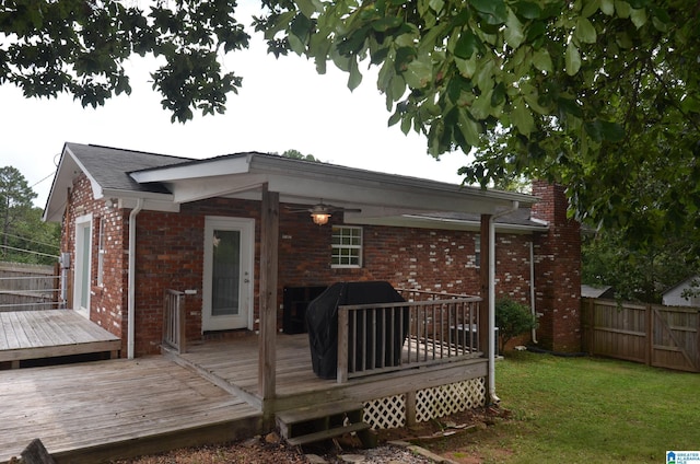 back of property with a wooden deck and a lawn