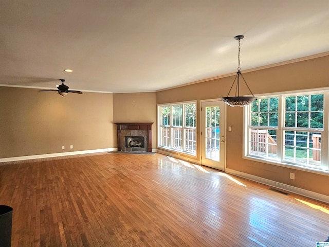 unfurnished living room featuring ceiling fan, a fireplace, crown molding, and light hardwood / wood-style floors