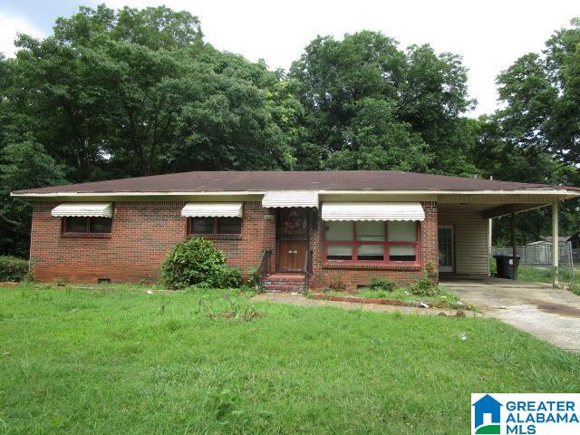 ranch-style house with a carport and a front yard