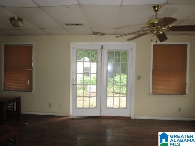 doorway with hardwood / wood-style floors, ceiling fan, and a drop ceiling