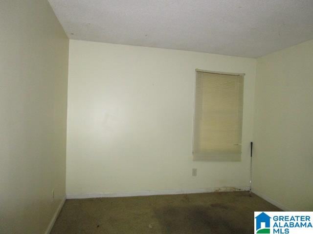 carpeted empty room featuring a textured ceiling