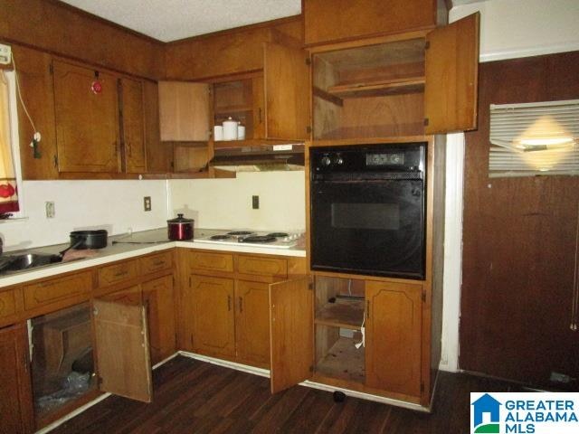 kitchen featuring oven, sink, gas stovetop, and dark hardwood / wood-style floors