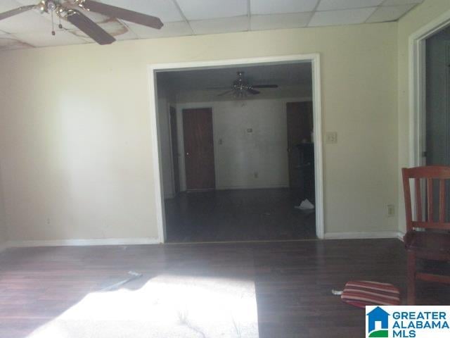 empty room with hardwood / wood-style flooring, a drop ceiling, and ceiling fan