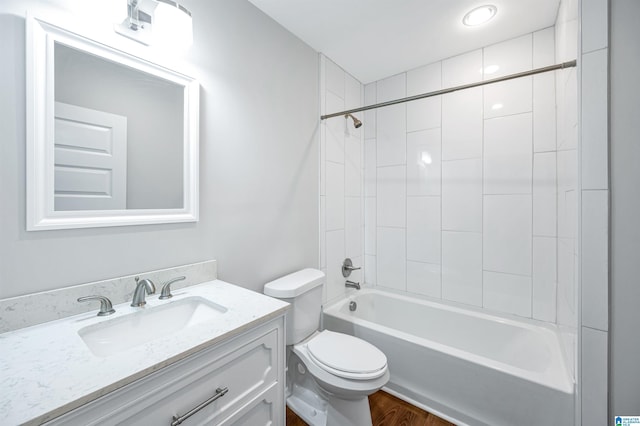 full bathroom with tiled shower / bath combo, vanity, and toilet