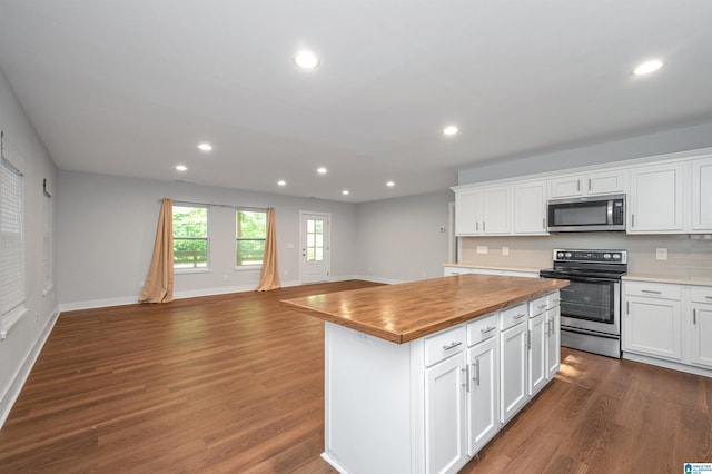 kitchen featuring butcher block countertops, a center island, appliances with stainless steel finishes, dark hardwood / wood-style flooring, and white cabinets