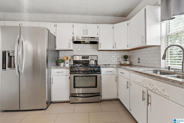 kitchen featuring light stone counters, sink, white cabinets, and appliances with stainless steel finishes