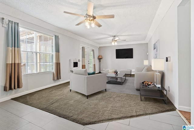 living room with tile patterned flooring, a textured ceiling, and ceiling fan