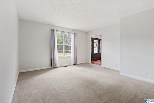 carpeted spare room with a textured ceiling