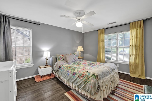 bedroom featuring ceiling fan, multiple windows, and hardwood / wood-style flooring