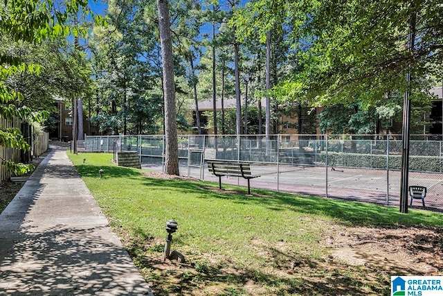 view of tennis court featuring a yard