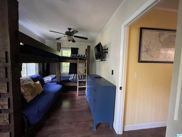 interior space featuring ceiling fan, a textured ceiling, dark hardwood / wood-style floors, and crown molding