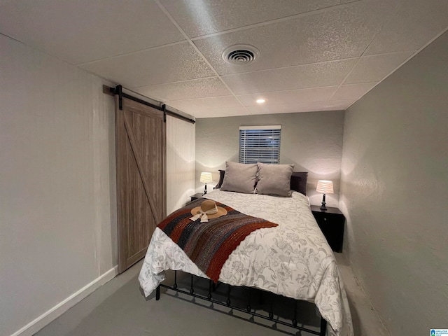 bedroom featuring a barn door and a paneled ceiling