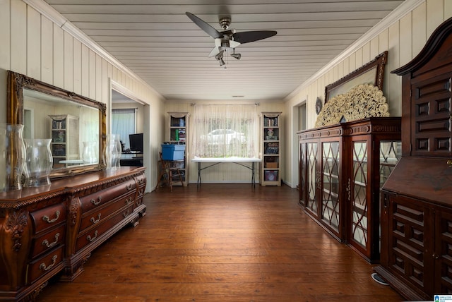 living area featuring crown molding, dark wood-type flooring, and ceiling fan