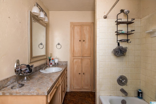 bathroom with tiled shower / bath and vanity