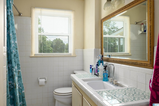 bathroom with vanity, tile walls, and toilet