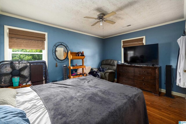 bedroom featuring dark hardwood / wood-style flooring, ceiling fan, crown molding, and a textured ceiling