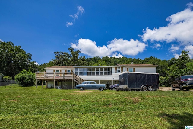 back of property featuring a carport, a yard, and a wooden deck