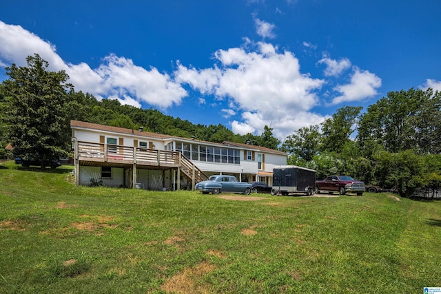 back of house featuring a wooden deck and a yard