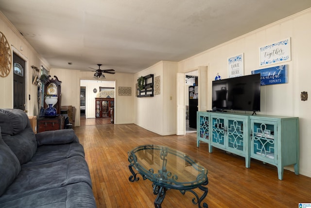 living room featuring hardwood / wood-style flooring, ornamental molding, and ceiling fan