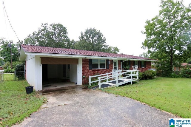 single story home featuring a front yard, a carport, and a porch