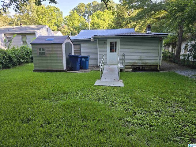 rear view of property with a storage unit and a lawn