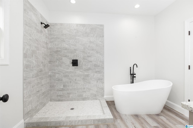 bathroom featuring shower with separate bathtub and hardwood / wood-style floors