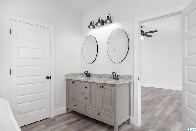 bathroom with double vanity, ceiling fan, hardwood / wood-style flooring, and crown molding