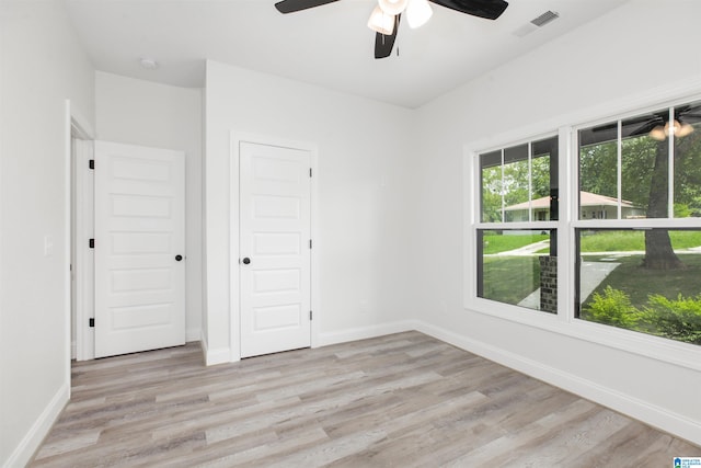 unfurnished bedroom featuring a closet, light wood-type flooring, and ceiling fan