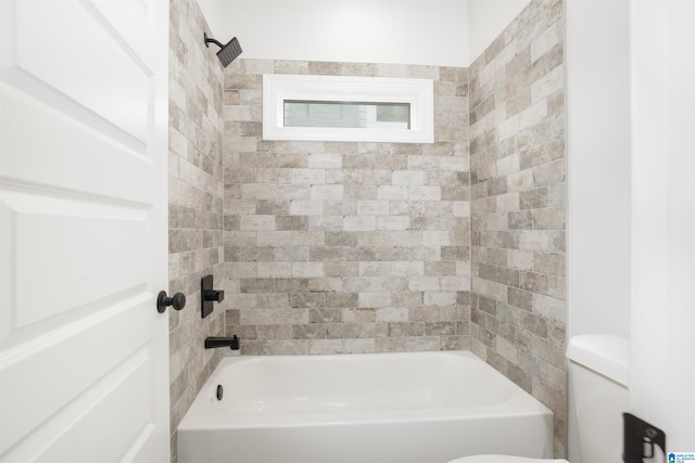 bathroom featuring toilet and tiled shower / bath