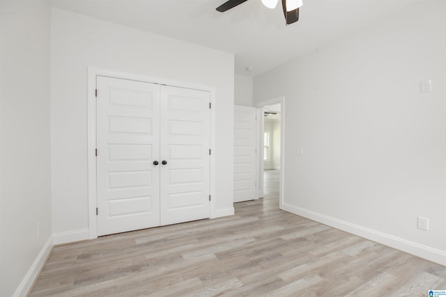 unfurnished bedroom with light hardwood / wood-style floors, a closet, and ceiling fan