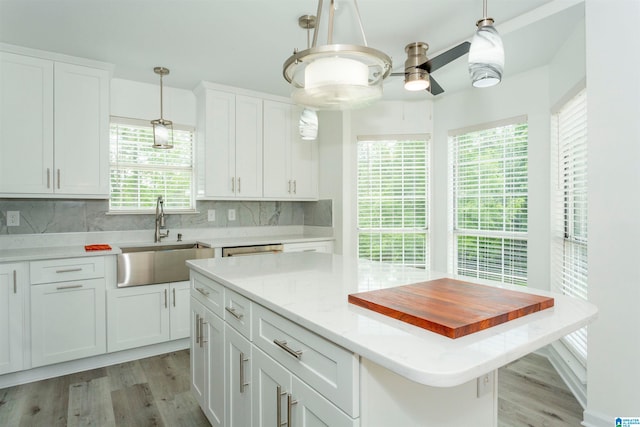 kitchen featuring a center island, light hardwood / wood-style floors, tasteful backsplash, and sink